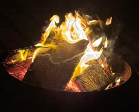 Loderndes Feuer in einer Feuerschale bei Nacht